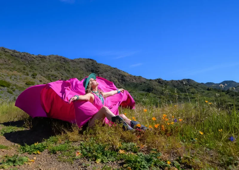 Woman sitting in nature during a flying dress experience photoshoot