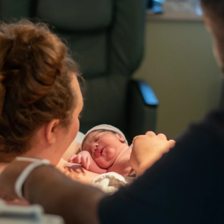 Best napa photographer for baby birth in Napa taking photo of mother holding baby in the hospital just after birth