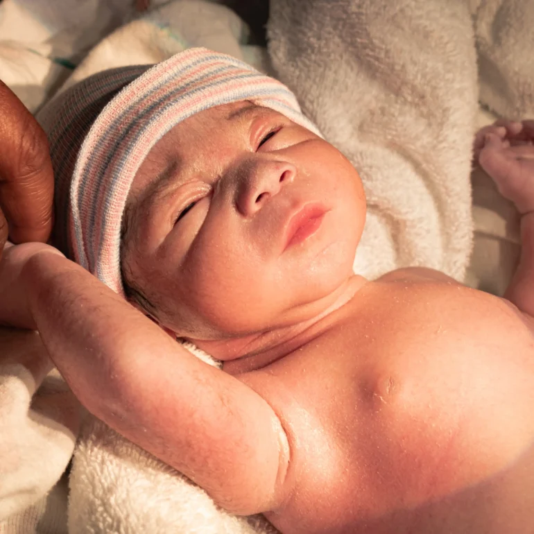 Newborn baby with new Dad holding his hand photographed by Napa Valley birth photographer
