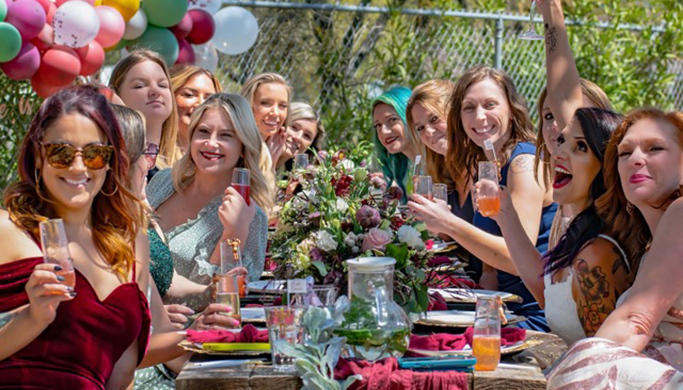 A group of young women celebrating at a bachelorette party drinking wine in napa valley california
