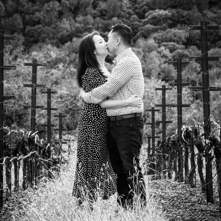 Newly engaged couple being photographed by Napa proposal photographer in a vineyard in black and white