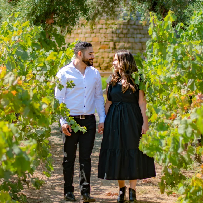 Napa proposal photographer taking photo of couple walking through vineyard in Napa Valley