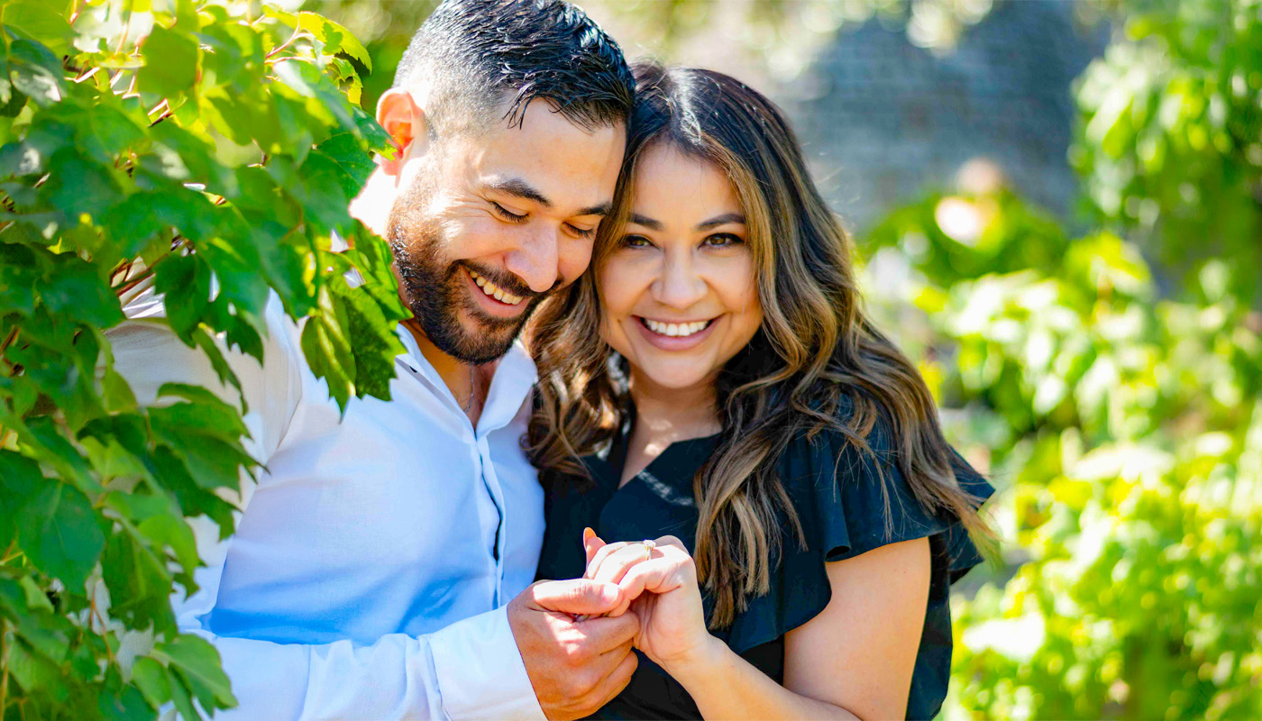 Napa proposal couple in vineyards smiling looking at engagement ring